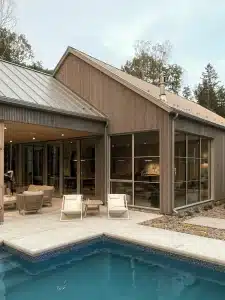 Architecture résidentielle intégrée au terrain, vue arrière de la Maison MJS avec terrasse.