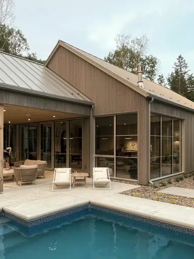 Architecture résidentielle intégrée au terrain, vue arrière de la Maison MJS avec terrasse.
