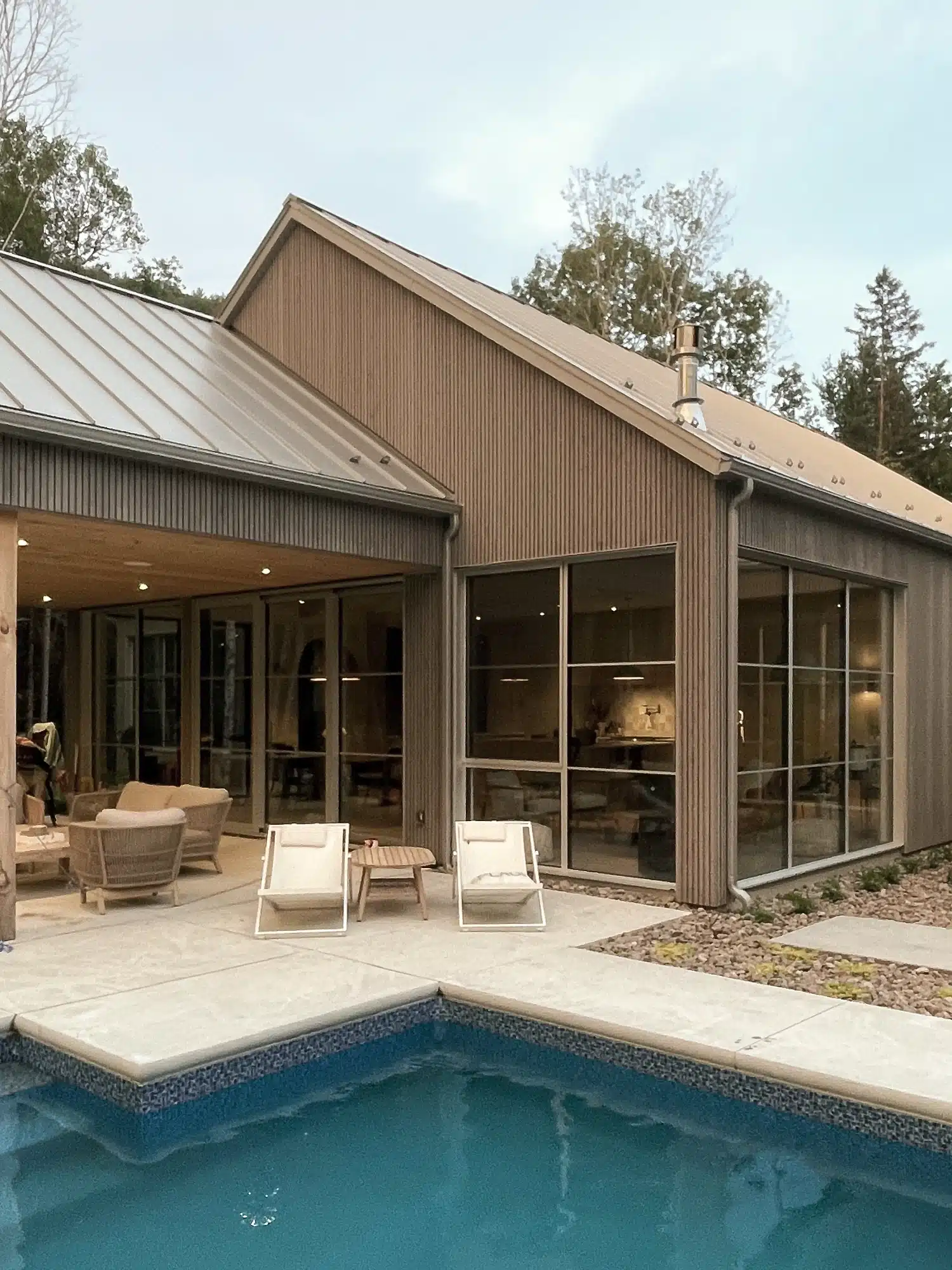Architecture résidentielle intégrée au terrain, vue arrière de la Maison MJS avec terrasse.