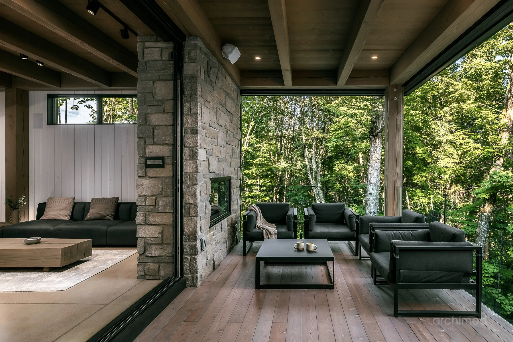 Terrasse avec foyer double face donant sur le salon intérieur, Montagne Noire - Archimede - Evolution Architecture