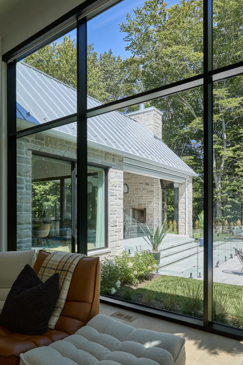 Entrée de la Maison S+J avec porte vitrée latéralement, imposte, luminaire suspendu et plancher de bois à chevrons.